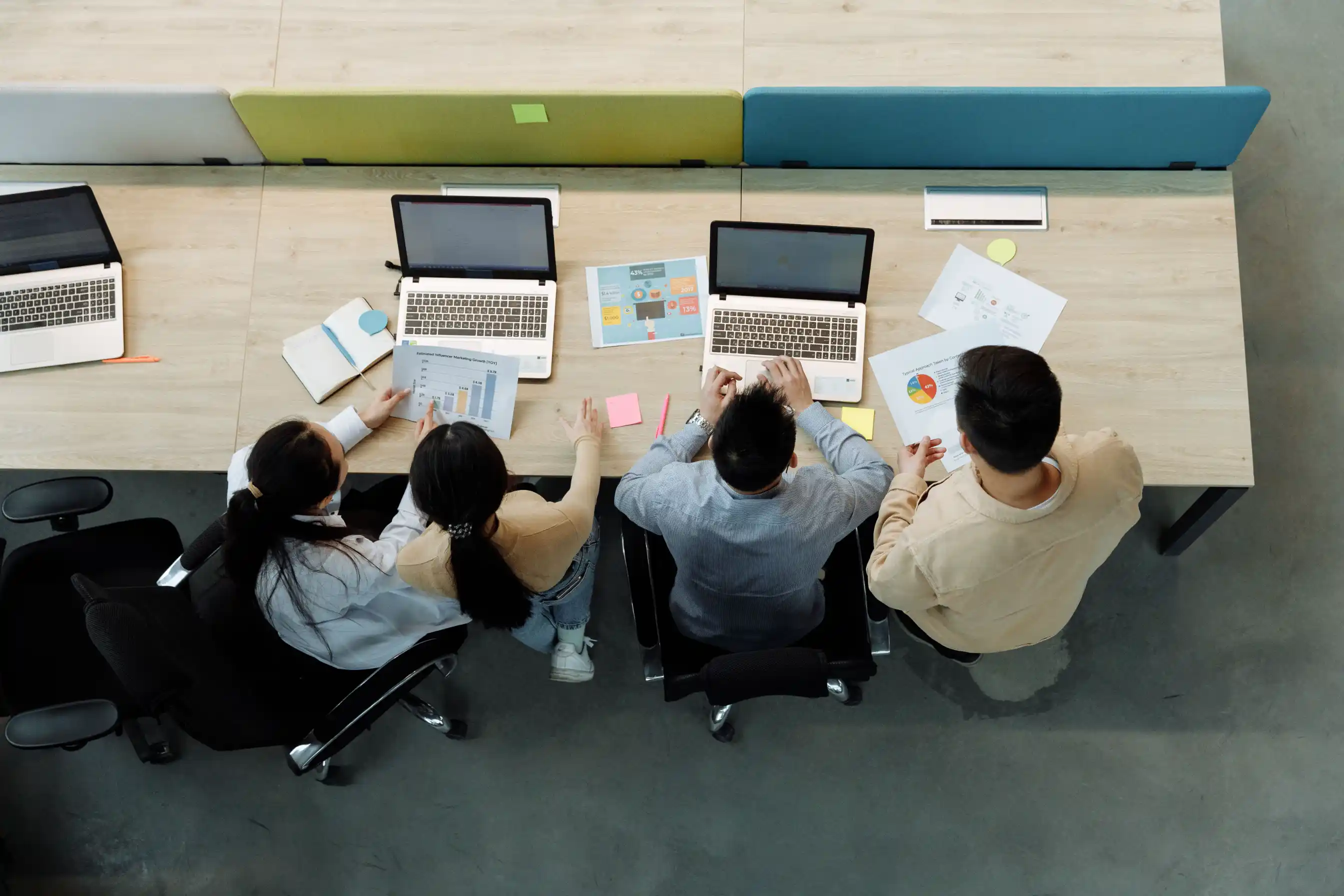 SaaS team working on laptops around an office table