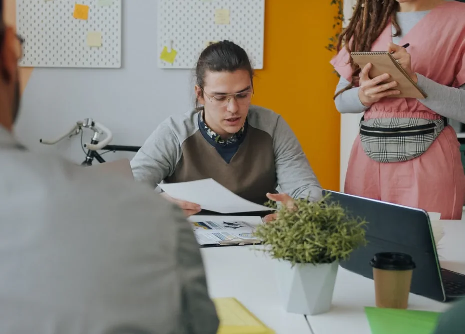 Startup team reviewing a marketing report together at a meeting table